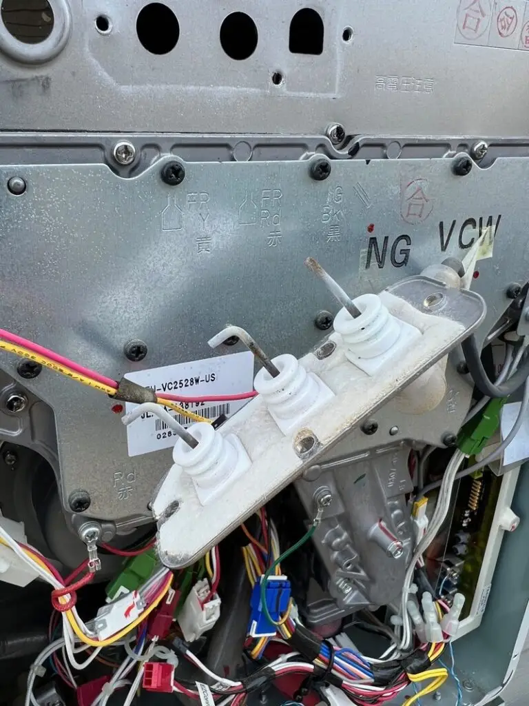 Tankless water heater burner and ignitor assembly exposed during maintenance